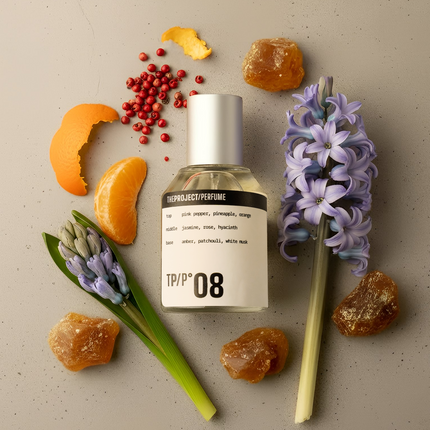 Perfume bottle with flowers and fruits on a beige background