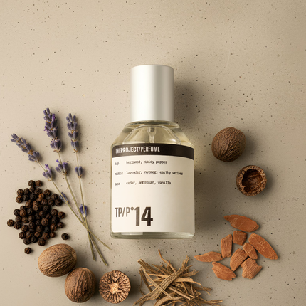 Perfume bottle labeled 'TPP14' surrounded by dried lavender, nuts, and other botanical elements on a beige background.